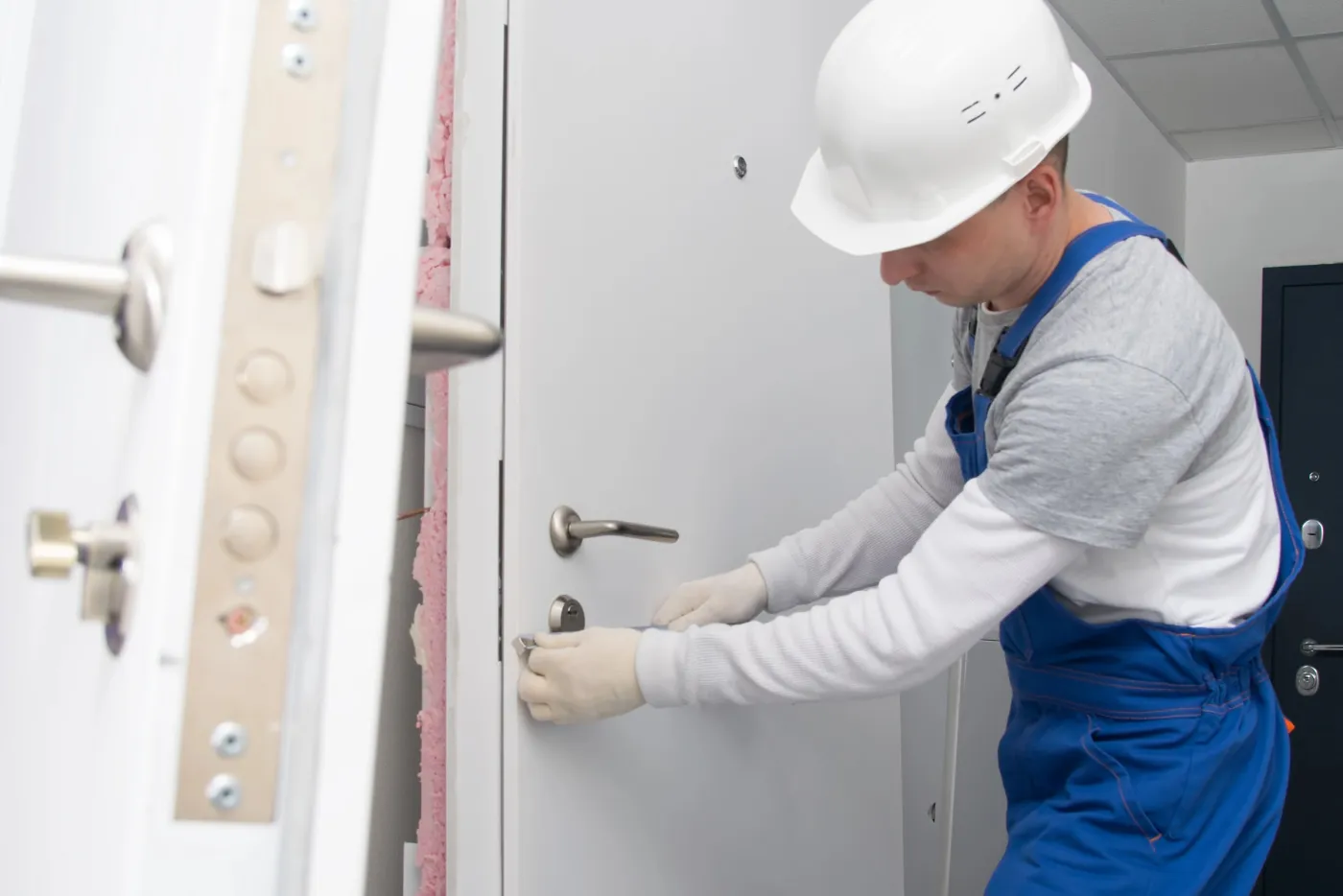 Pose d'une serrure sur une porte blindée d'immeuble à Sarcelles